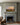 Sunrise landscape canvas with the verse new every morning centered over a sage grey fireplace mantel