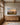 Largest 48 x 32 inch painting-style canvas of rolling hills at dawn above a long oak sideboard in a great room