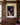 Dark storm-sky canvas of Christ in a cream linen robe between walnut bookcases in a den and study