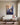 Jesus reaching toward a falling woman canvas hanging above an ivory linen sofa in a bright living room