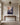 Christian wall art of Jesus reaching down from flowers into a dark blue gulf, above a walnut console in an entry hall