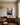 Painting-style canvas of two hands about to meet in warm light, displayed above a mahogany sideboard in a dining room
