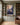 Jesus and the falling woman canvas on olive green built-in panelling between bookshelves in a home library