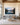 Largest 48 by 32 inch lake sunrise canvas above a long grey boucle sofa in a great room with fir trusses