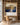 Panoramic canvas of Jesus beneath a golden tree set into oak bookshelves above a writing desk and leather chair