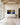 The panoramic canvas on a tall limestone wall in a great hall with exposed timber beams and a long upholstered bench