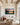 Sunset river canvas with Love the Lord your God verse above an ivory linen sofa in a beamed living room