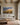 Painting-style Jeremiah 29:11 canvas with a prairie road and sunrise horizon above a linen sofa in a beamed living room