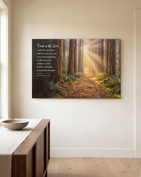 Front view of a painting-style canvas of a sunlit forest path with the Trust in the Lord verse, hanging on an ivory plaster wall