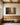 Large painting-style forest path scripture canvas above an oak bench and wainscot in a church prayer room with arched windows