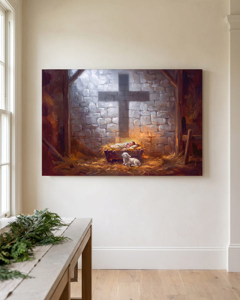 Nativity canvas with the shadow of a cross on a stone stable wall, hung on an ivory plaster wall beside a console dressed with fresh cedar