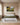 Psalm 23 painting-style canvas print above an upholstered linen headboard in a calm, daylit primary bedroom