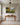 Small 24x16 painting-style canvas of still waters and green pasture above a cherry console table in an upstairs hallway outside the bedrooms