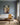 Portrait canvas of the lamb and Jesus in the stream above an ivory linen sofa in a blue-grey living room
